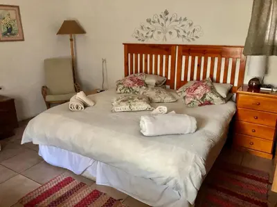 a bedroom with a large bed with towels on it at La Bella B&B Under The Fig Tree in Bela-Bela