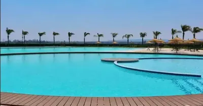 a large swimming pool with palm trees and umbrellas at Kayalako at The Blyde 2 in Pretoria