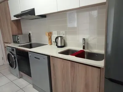 a kitchen with a sink and a washing machine at Kayalako at The Blyde 2 in Pretoria