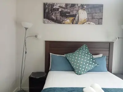 a bedroom with a bed with blue and green pillows at Kayalako at The Blyde 2 in Pretoria