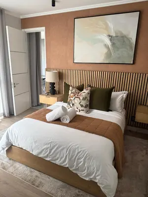 a bedroom with a large bed with a wooden headboard at Cassini Dreaming in Northdene