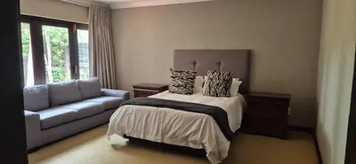 a bedroom with a bed and a couch at Luxury oasis retreat in Hartbeespoort