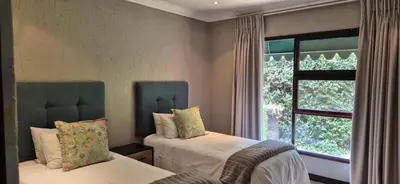 a bedroom with two beds and a window at Luxury oasis retreat in Hartbeespoort