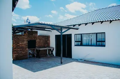 a patio with a brick fireplace and a roof at Karabelo guesthouse in Groblersdal