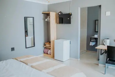 a bedroom with a bed and a tv on a wall at Karabelo guesthouse in Groblersdal