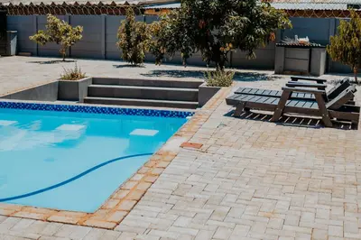 a swimming pool with a picnic table and a bench at Karabelo guesthouse in Groblersdal