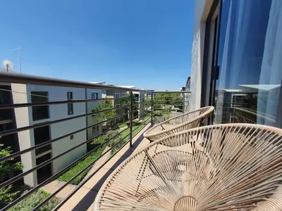 a balcony with two tables and chairs on a building at Studio Apartment near Dainfern Golf Club I Montecasino I Indaba Hotel in Sandton