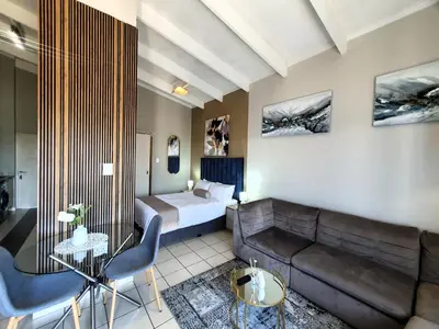 a hotel room with a couch and a bed at Studio Apartment near Dainfern Golf Club I Montecasino I Indaba Hotel in Sandton