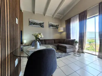 a living room with a couch and a table at Studio Apartment near Dainfern Golf Club I Montecasino I Indaba Hotel in Sandton