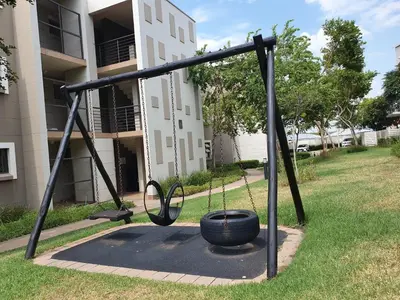 a swing in a yard in front of a building at Studio Apartment near Dainfern Golf Club I Montecasino I Indaba Hotel in Sandton