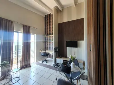 a living room with a desk and chairs in a room at Studio Apartment near Dainfern Golf Club I Montecasino I Indaba Hotel in Sandton