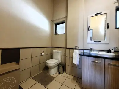 a bathroom with a toilet and a sink at Studio Apartment near Dainfern Golf Club I Montecasino I Indaba Hotel in Sandton