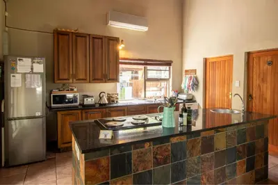 a kitchen with a refrigerator and a counter top at Woodlandsbushlodge in Hoedspruit