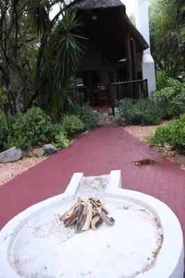 a concrete bowl with sticks in it in front of a house at Woodlandsbushlodge in Hoedspruit