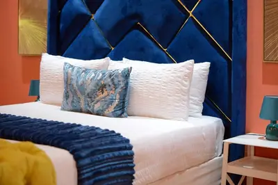 a bed with a blue head board and pillows at Kneizenberg Boutique Lodge & Spa in Louis Trichardt