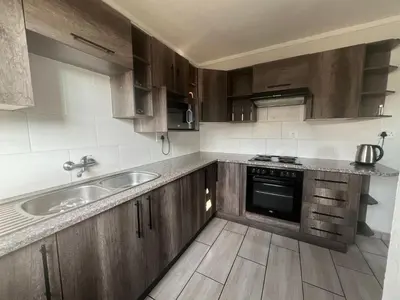 a kitchen with wooden cabinets and a sink at 50 at Terrace in Nelspruit