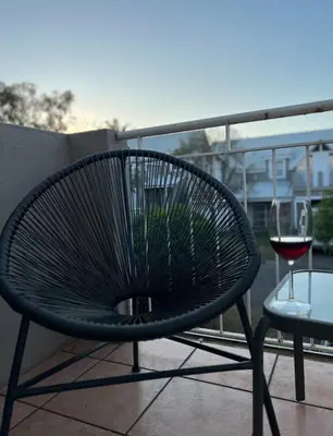 a black chair and a glass of wine on a balcony at 50 at Terrace in Nelspruit