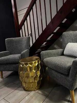 two chairs and a stool next to two chairs and a staircase at 50 at Terrace in Nelspruit