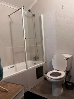 a bathroom with a toilet and a shower and a tub at 50 at Terrace in Nelspruit