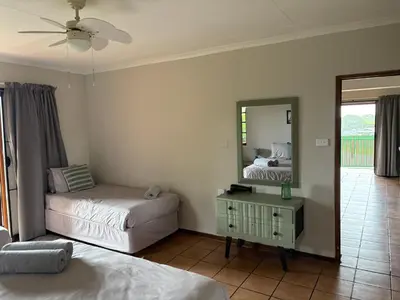 a bedroom with two beds and a mirror at The Gem Emerald in Graskop