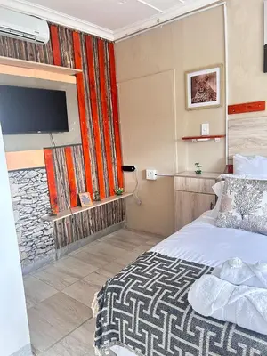 a bedroom with a bed and a flat screen tv at MRH Self Check- In Express Homestay in Modimolle