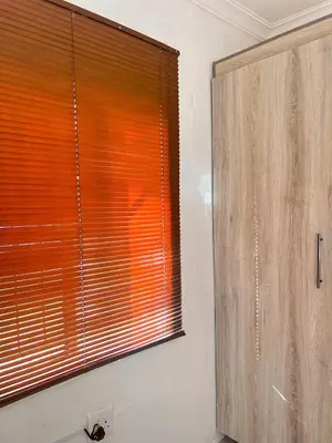 a bathroom with a window and a wooden cabinet at MRH Self Check- In Express Homestay in Modimolle