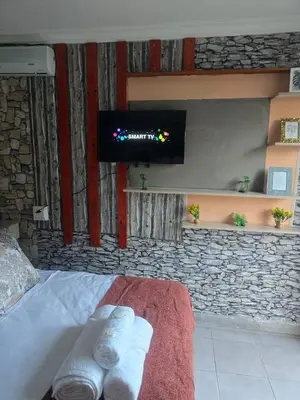 a room with a tv and a bed with towels at MRH Self Check- In Express Homestay in Modimolle