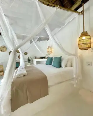 a white bedroom with a bed with a canopy at Hot spring tiny home in Limpopo in Gemsbokfontein