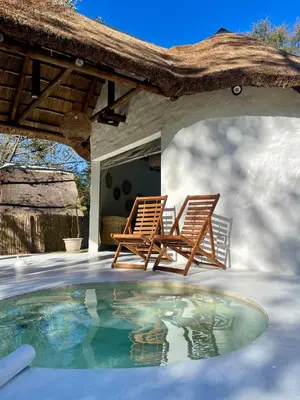 two chairs and a swimming pool on a patio at Hot spring tiny home in Limpopo in Gemsbokfontein