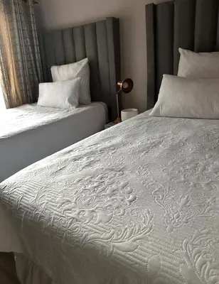 a bedroom with two beds with white sheets at Riverside Gardens 2 bedroom Home in Nelspruit