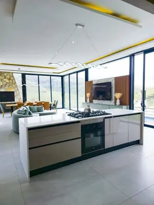 a kitchen with a stove and a living room at The Curve in Dullstroom