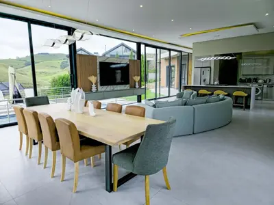 a dining room and living room with a table and chairs at The Curve in Dullstroom