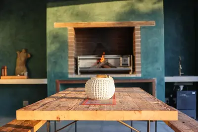 a wooden table with a fireplace in a room at Bush House Zandspruit in Hoedspruit