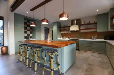 a kitchen with a large island with bar stools at Bush House Zandspruit in Hoedspruit