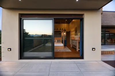 a sliding glass door of a house with a patio at Bush House Zandspruit in Hoedspruit