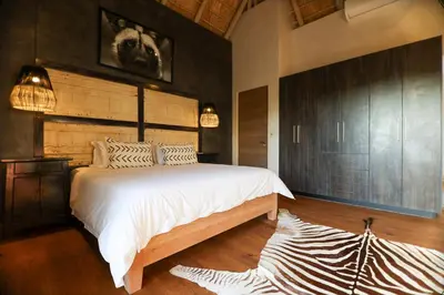 a bedroom with a large bed in a room at Bush House Zandspruit in Hoedspruit