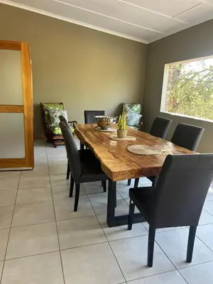a dining room with a wooden table and chairs at Maroela 1022 in Marloth Park