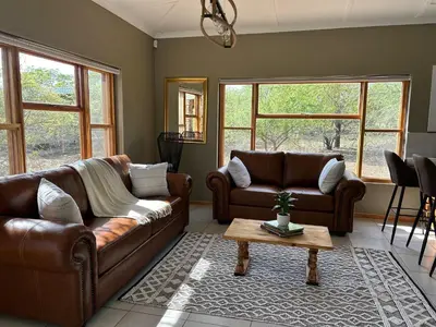 a living room with two couches and a coffee table at Maroela 1022 in Marloth Park
