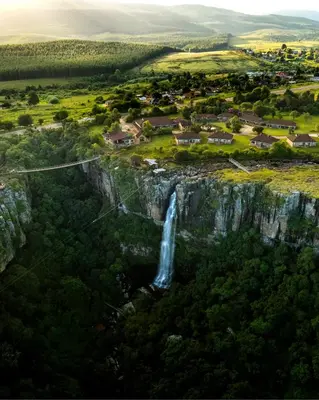 an aerial view of a waterfall on a cliff at Mogodi Lodge in Graskop