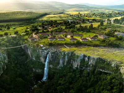 an aerial view of a waterfall on a cliff at Mogodi Lodge in Graskop