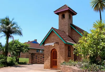 a brick church with a clock tower on top at Mogodi Lodge in Graskop