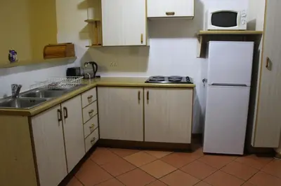 a kitchen with a white refrigerator and a sink at Mogodi Lodge in Graskop