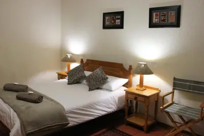 a bedroom with two twin beds and two lamps at Mogodi Lodge in Graskop