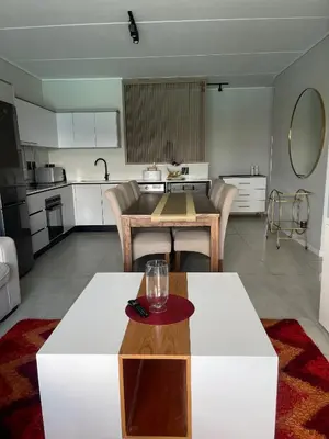 a living room with a table and a kitchen at UNIT 1487 The blyde crystal lagoon in Pretoria