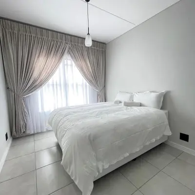a white bedroom with a large bed and a window at UNIT 1487 The blyde crystal lagoon in Pretoria