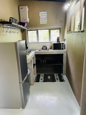 a small kitchen with a sink and a refrigerator at Shiringa kruger lodge in Marloth Park