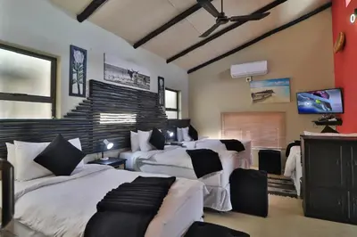 a large bedroom with two beds and a tv at Shiringa kruger lodge in Marloth Park