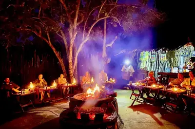 a group of people sitting at tables in front of a tree at Fevertree Private Lodge in Warmbaths