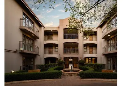 a large building with a fountain in front of it at Cozy Apartment in Hatfield in Pretoria