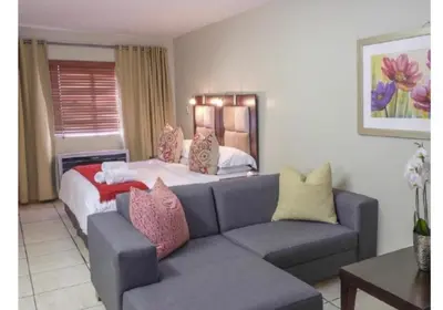 a living room with a couch and a bed at Cozy Apartment in Hatfield in Pretoria
